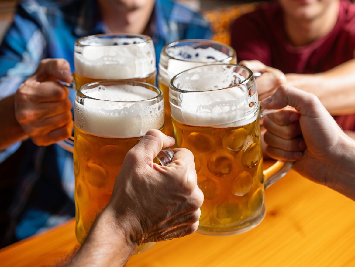 Люди держат кружки пива